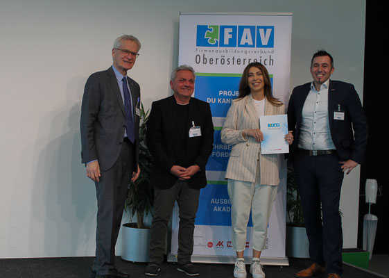 Absolvent:in präsentiert die Urkunde gemeinsam mit Gratulanten