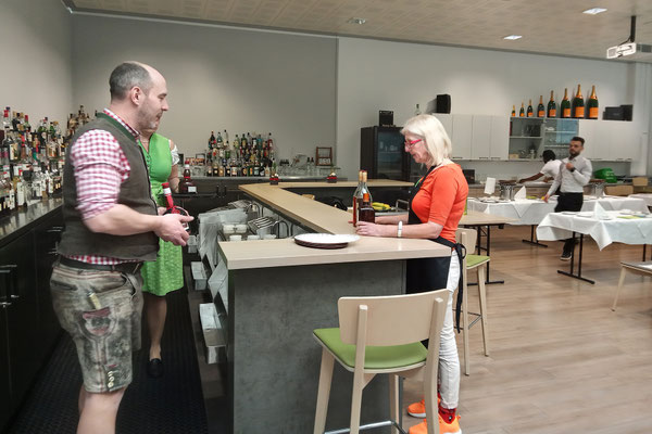 Teilnehmender spricht mit der Trainerin an der Bar im Schulungsraum