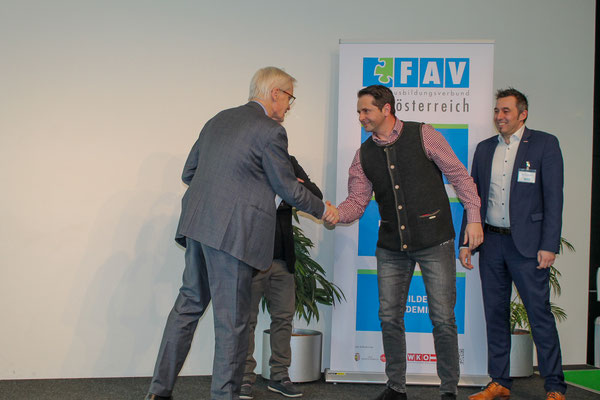 Projektleitung und Vereinsobmann gratulieren Absolvent zur erhaltenen Urkunde