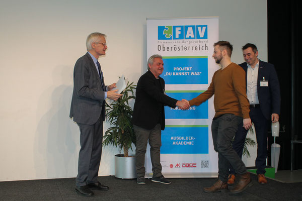 Urkundenverleihung auf der Bühne mit Händedruck durch die Vertreter von WKOÖ und AK OÖ