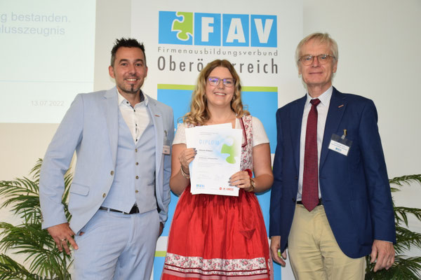 Absolventin mit überreichter Urkunde und Vertretern des FAV OÖ