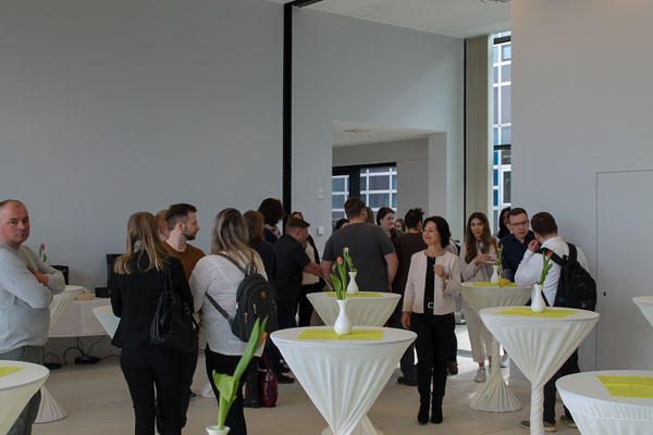 Teilnehmer:innen und Gäste beim gemeinsamen Ausklang an Stehtischen