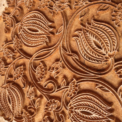 Nahaufnahme eines kunstvoll geschnitzten Blockprint-Stempels, der das Herzstück eines jeden einzigartigen Textildrucks darstellt