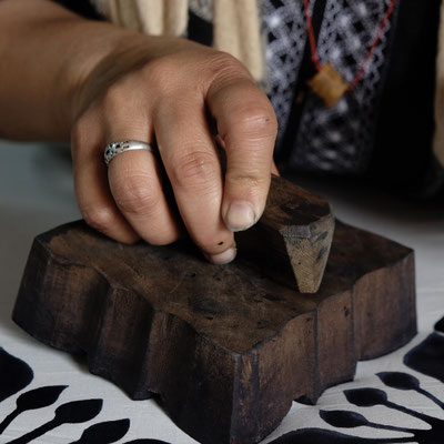 Eine Druckerin bei Maasa Production in unserer Manufaktur in Delhi bringt den Blockprint-Stempel mit größter Sorgfalt auf den Stoff auf, um ein kunstvolles Design zu schaffen.