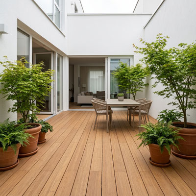 Großzügige Balkonterrasse, erstellt mit den AMBOOO Closed Decking Dielen. Die Terrassendielen sind längs verlegt und werden von einem modernen anthrazitfarbenen Metallgeländer eingefasst. 