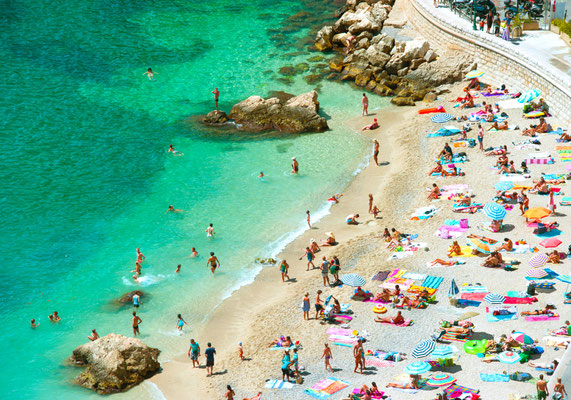 beach of the Cote d'Azur with tourists with sunbeds and umbrellas on the hot summer day Copyright LiliGraphie