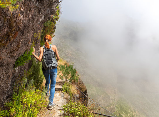 Young woman walking in the path on the mountain edge, Portugal, Madeira Copyright Nomad_Soul