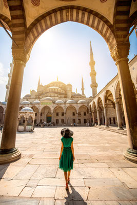 Young woman traveler in the green dress and hat walking to the Blue Mosque in Istanbul - Copyright RossHelen