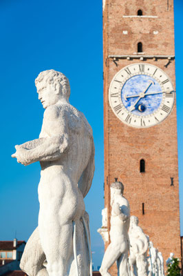 Statues on the top of the Basilica palladiana, the main monument of the town Vicenza and the clock tower copyright Marco Ossino