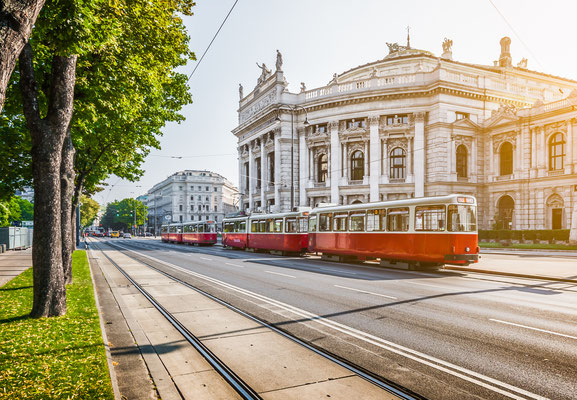 Famous Wiener Ringstrasse with historic Burgtheater (Imperial Court Theatre) and traditional red electric tram Copyright canadastock