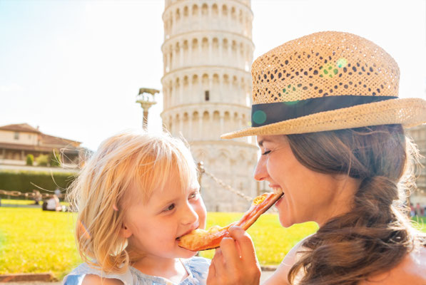 Happy mother and baby girl eating pizza in front of leaning tower of Pisa, Italy - Copyright Alliance