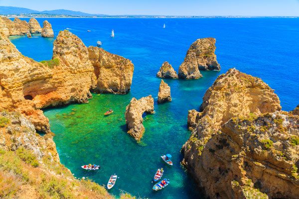 Fishing boats on turquoise sea water at Ponta da Piedade, Algarve region, Portugal by Pawel Kazmierczak