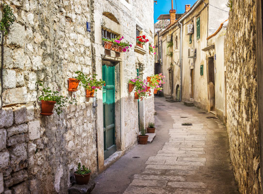 Narrow old street and yard in Sibenik city, Croatia, medieval zone by