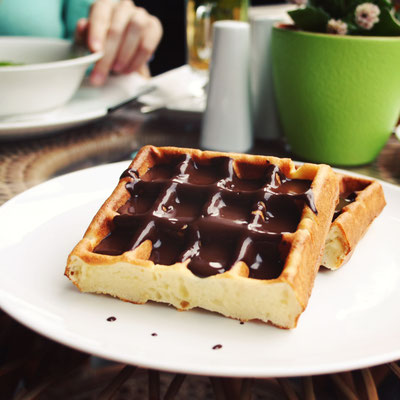 Viennese Waffles covered with chocolate. Aged photo. Vienna Waffles covered with chocolate topping. White plate with sweet food Copyright Lora Sutyagina