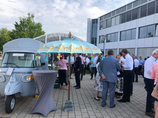 After Work Firmenevent mit mobiler Secco Ape von Secco Princess vor einem Unternehmensgebäude in Hessen – entspannte Firmenfeier mit Mitarbeitern und Kunden, stilvolle mobile Bar als Highlight für Corporate Event und Sommerfest.