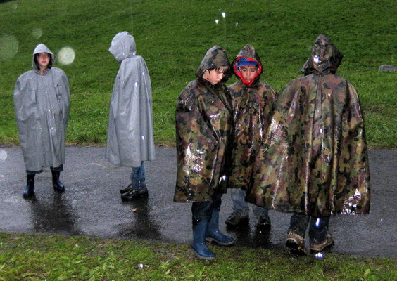 Die Kinder in den Pelerinen sind wenig beeindruckt vom starken Regen 