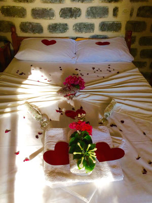 decorated wedding bed with red hearts and flowers