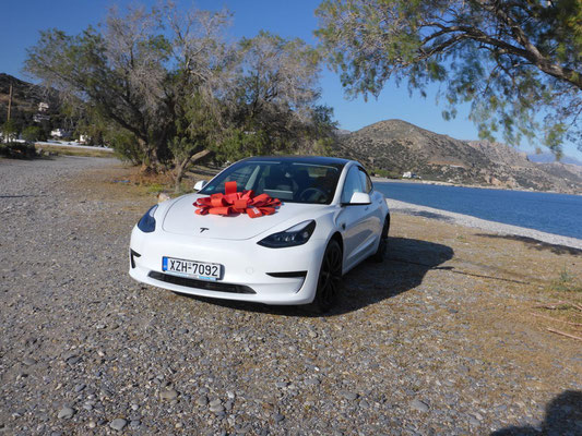 white Tesla with red bow