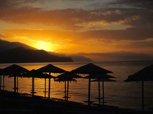 Sonnenschirme und Sonnenuntergang am Strand von Palaiohora auf Kreta