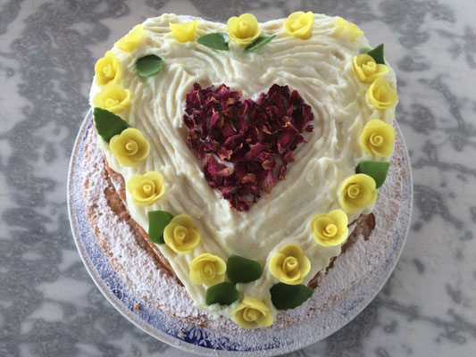 cake for a golden wedding anniversary with yellow flowers and a red heart in the middle