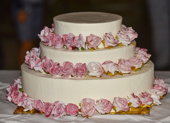 Hochzeitstorte mit rosa Blüten in drei Lagen