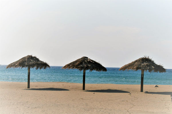 umbrellas at the sandy beach in Paleochora Crete with the blue sea in the background