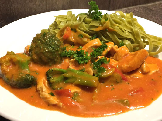 Putengeschnetzeltes an Tomaten-Sahnesauce mit Brokkoli an grünen Bandnudeln