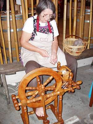 Isabelle en train de filer la laine au rouet 