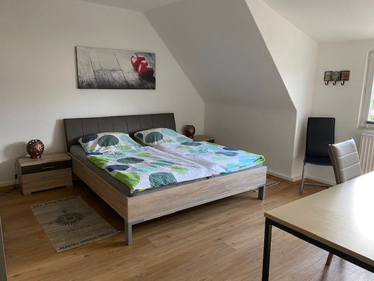 Blick in das Schlafzimmer mit großem Doppelbett