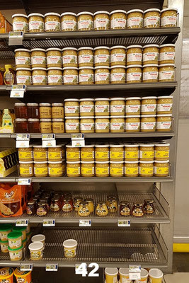 Gut gefülltes Honigregal im Supermarkt mit unserem lokalproduzierten Honig.
