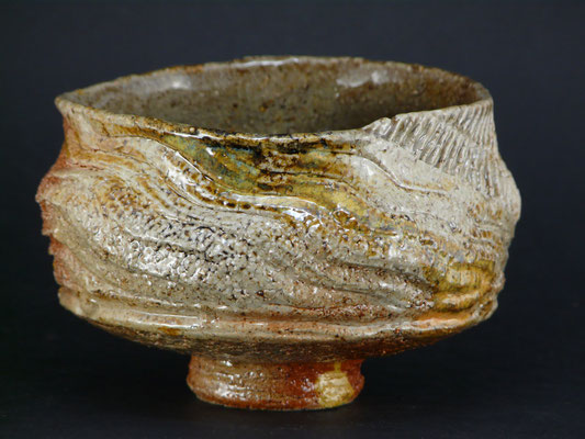 un bol brut en grès chamoté blanc typique des grès au sel cuit au bois, marqué de vagues et de sillons accompagnant bien cette magnifique forme portant les traces du modelage.