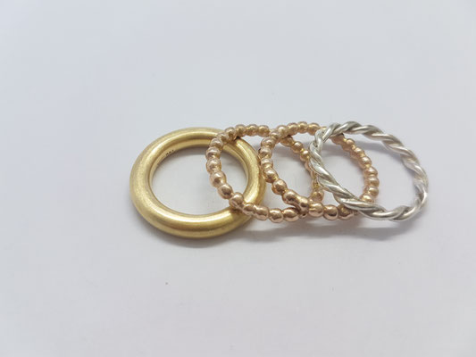 eine mixtur: 750/000 gelbgold, kügelchenringe 585/000 rosegold und ein gedrehter ring aus 925/000 silber.