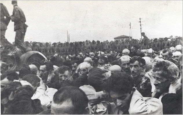 Białystok Ghetto, 15-20. August 1943. Jüdische Männer mit Händen hinter dem Nacken, beobachtet von einer deutschen Militäreinheit