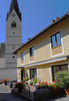 Pension Kirchenwirt Außenansicht mit Pfarrkirche Obervellach