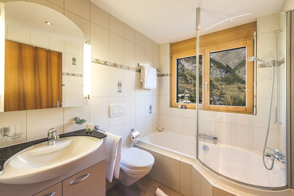 Modern bathroom with bathtub and stunning mountain view.