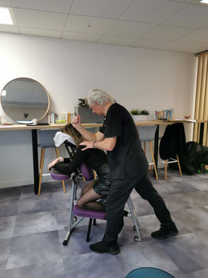 Massage amma assis en entreprise avec collaborateur recevant un soin sur chaise ergonomique