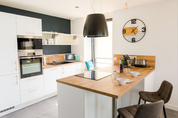 Cuisine avec bar et assises hautes dans un appartement contemporain lumineux proche du bord de mer
