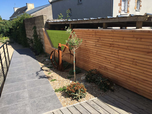 Aménagement extérieur avec terrasse, cheminement en dalles, rampe PMR, bardage bois et espace paysager.