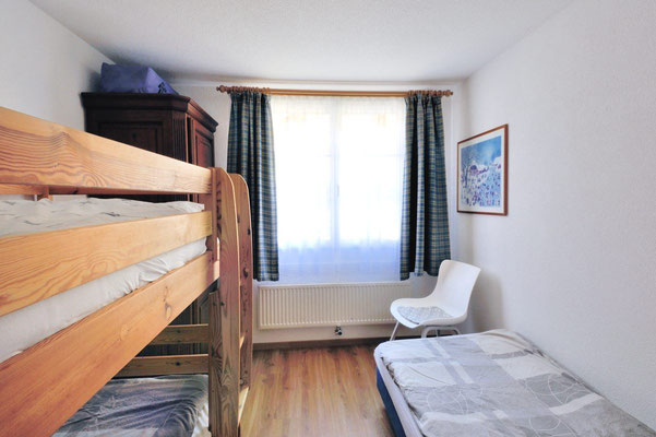 Im Kinderzimmer inks Kajütenbett, rechts Einzelbett, geradeaus Blck auf Fenster und 5. Stuhl für die Essecke