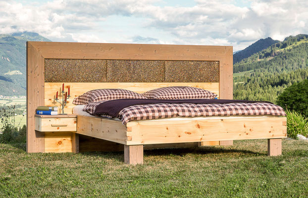 Zirbenbett mit Kräuter-Kopfteil in einer Alpen-Landschaft