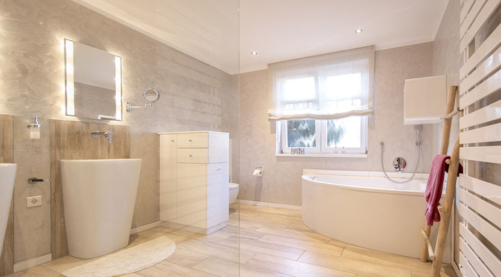 Modernes Badezimmer mit freistehender Badewanne, Waschtisch und heller Fliesengestaltung von Friedrich Lindhorst GmbH in Achim