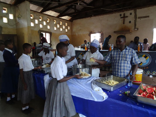 Gemeinsames Essen eines von den mitgereisten Lehrern gestifteten Mittagsessens an der Schule. Joseph und die Tumaini Gruppe haben ein leckeres Essen gezaubert.