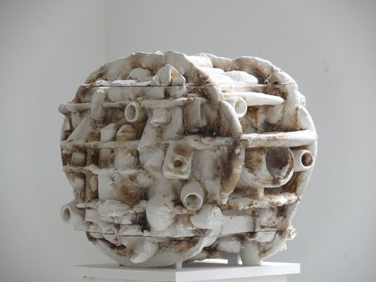 zeitgenössische Skulptur von Andreas Jonak, weisser kugelähnlicher Körper mit zerklüfteter Öberfläche, Stege und Löcher, reste vn Brauner Substank in den Vertiefungen