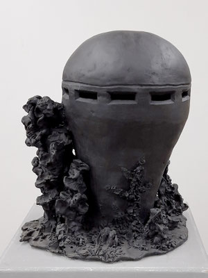 zeitgenössische Skulptur von Andreas Jonak, schwarzer Bunker mit Schlitzen und Bäumen auf Sockel