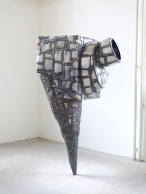 zeitgenössische Skulptur von Andreas Jonak, aus metallplatten zusammengeschweite Kubische form mit zylindrischem Fuße, nur an einem Punkt mit dem Boden verbunden, netzartige Schweißnähre über die ganze Oberfläche verteilt