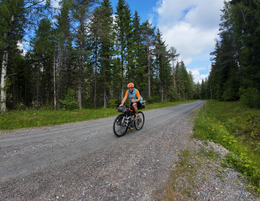 Bikepacker auf Schotterstraße durch Waldgebiet bei Kloten in Schweden