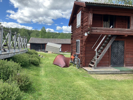 Bikepacking-Zelt neben rotem Holzhaus in Malingsbo in Schweden