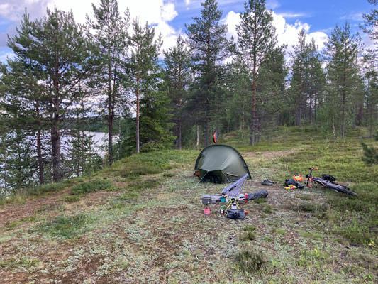 Wildcamping-Zelt im Wald nahe einem See in Lappland auf Bikepacking-Tour