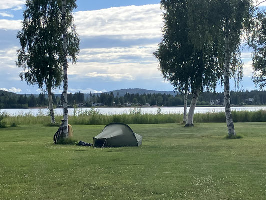 Bikepacking-Zelt auf Wiese am See bei Öjebyn in Nordschweden