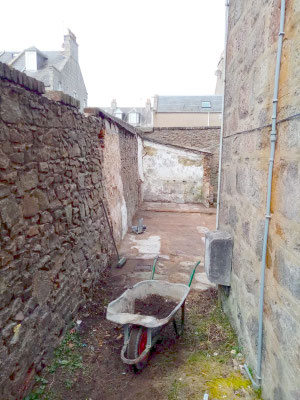 Side view of property with wheelbarrow in foreground and cleared site after outbuilding demolition on Bloomfield Road, Aberdeen.